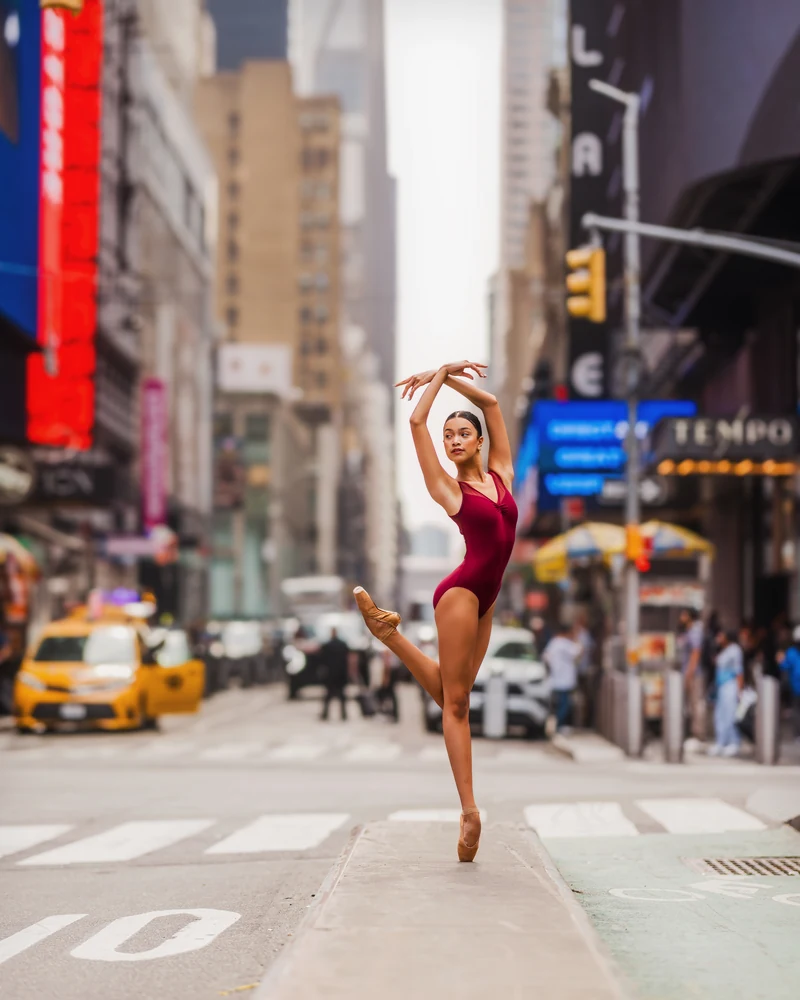 Grace en pointe in a burgundy leotard on a New York street