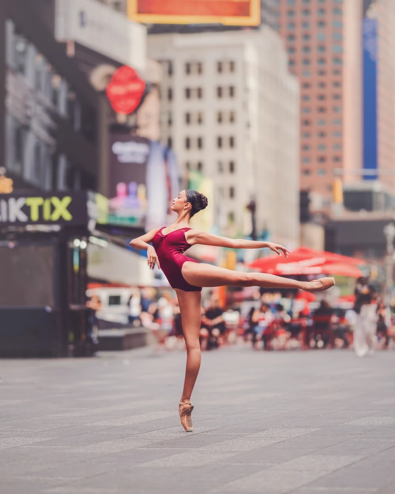 Grace extending one leg while balancing en pointe in Times Square